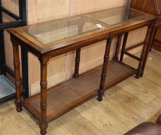 A reproduction walnut two tier side table, the top inset plate glass panels W.132cm